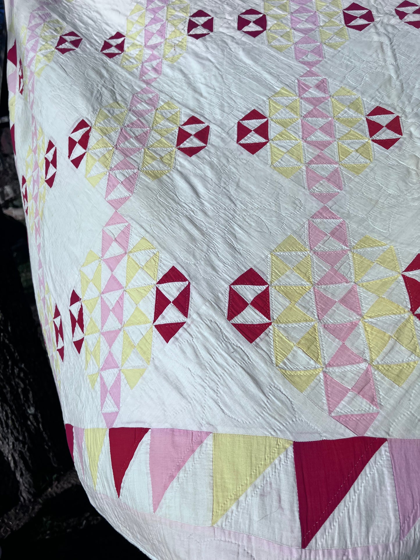 This lovely has white, red, pink and yellow, intricate triangles and hand quilting and stitching