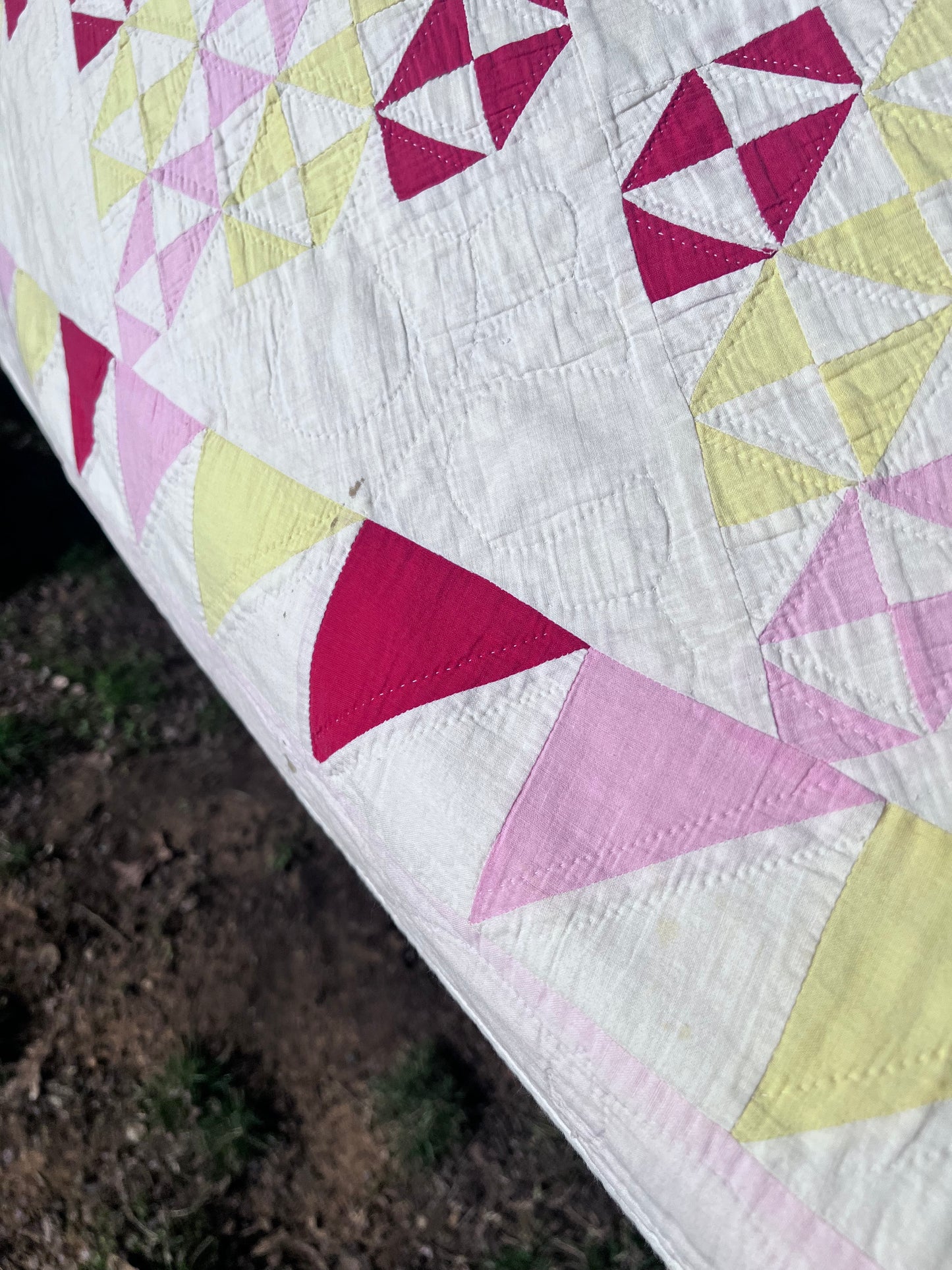 This lovely has white, red, pink and yellow, intricate triangles and hand quilting and stitching