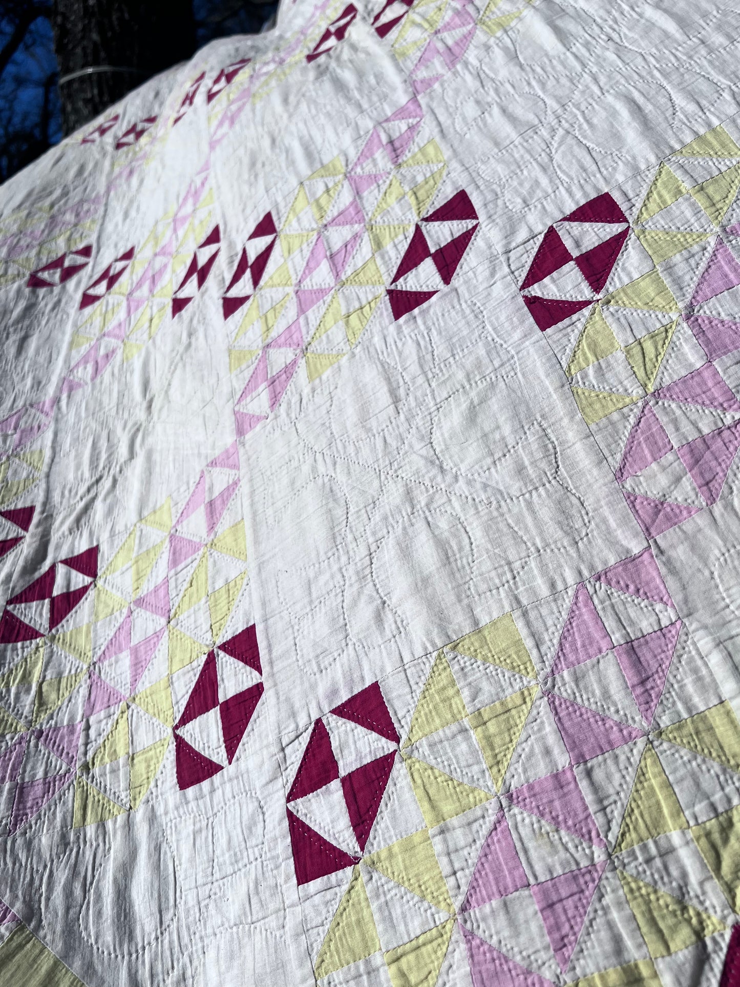 This lovely has white, red, pink and yellow, intricate triangles and hand quilting and stitching
