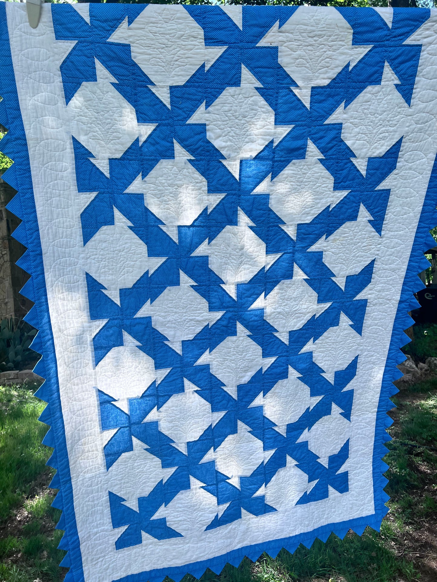 Blue & White twin size drunkards path with a sawtooth border has excellent hand quilting