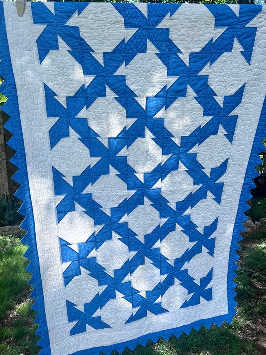 Blue & White twin size drunkards path with a sawtooth border has excellent hand quilting